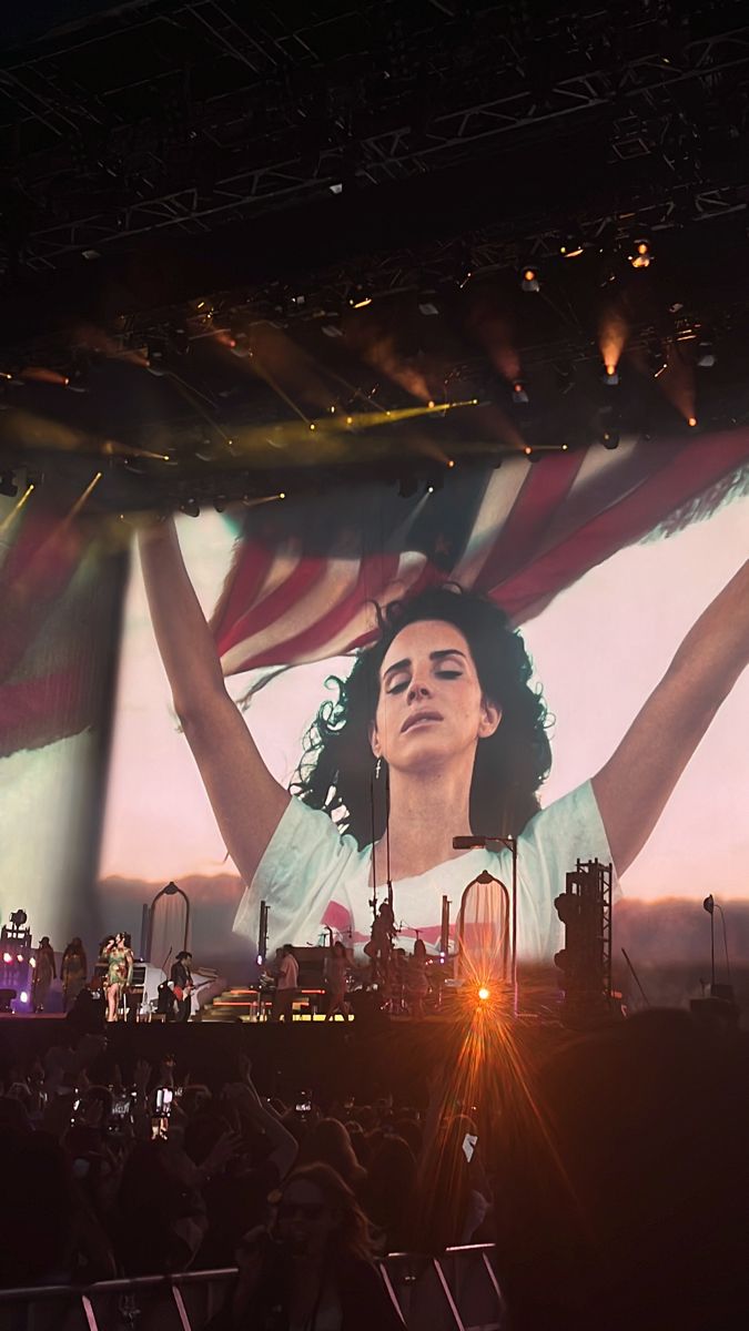 a large screen with a woman holding an american flag