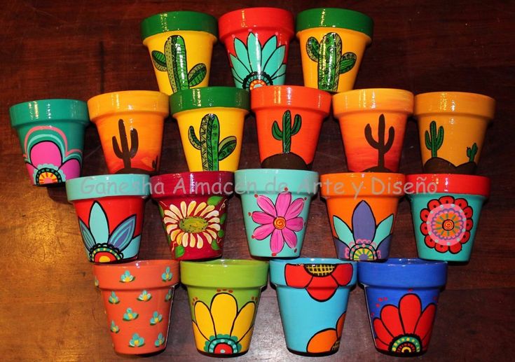 many colorful flower pots are stacked on top of each other in the shape of cactuses