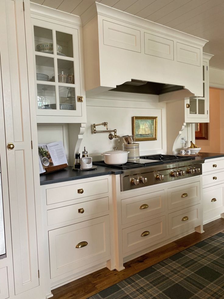 a kitchen with white cabinets and black counter tops is pictured in this image from the front view