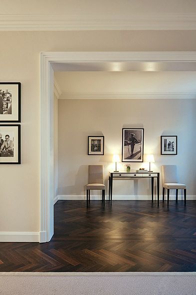 a living room filled with furniture and pictures on the wall