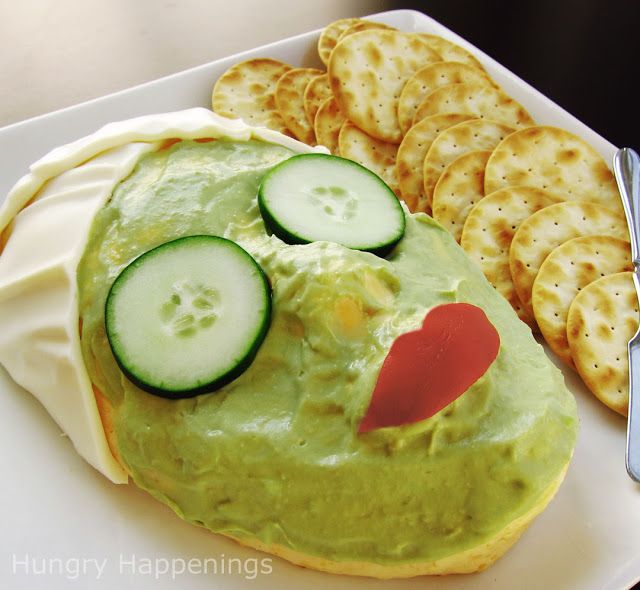 a plate with crackers, cucumber and cheese on it