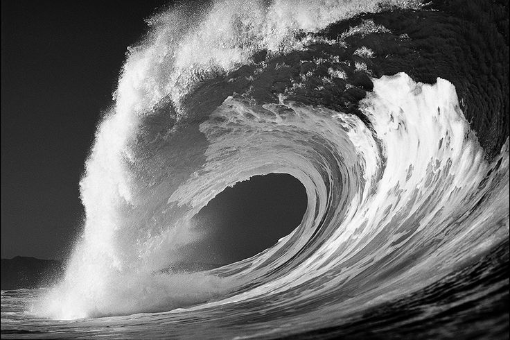 a black and white photo of a large wave