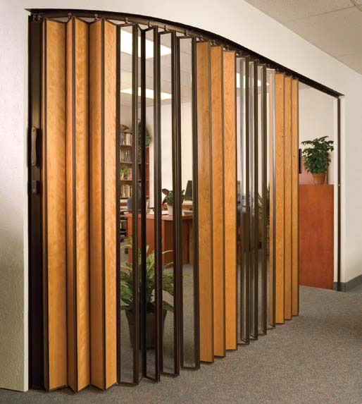 an office area with wooden partitions and plants in the corner, along with glass walls