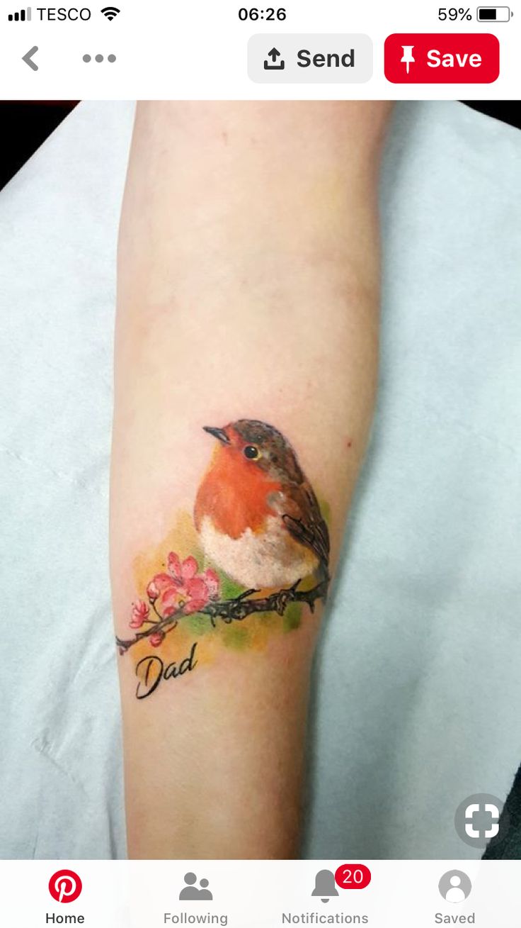 a small bird sitting on top of a branch with flowers in it's beak