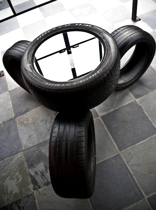 two tires sitting on top of each other in the middle of a room with tile flooring