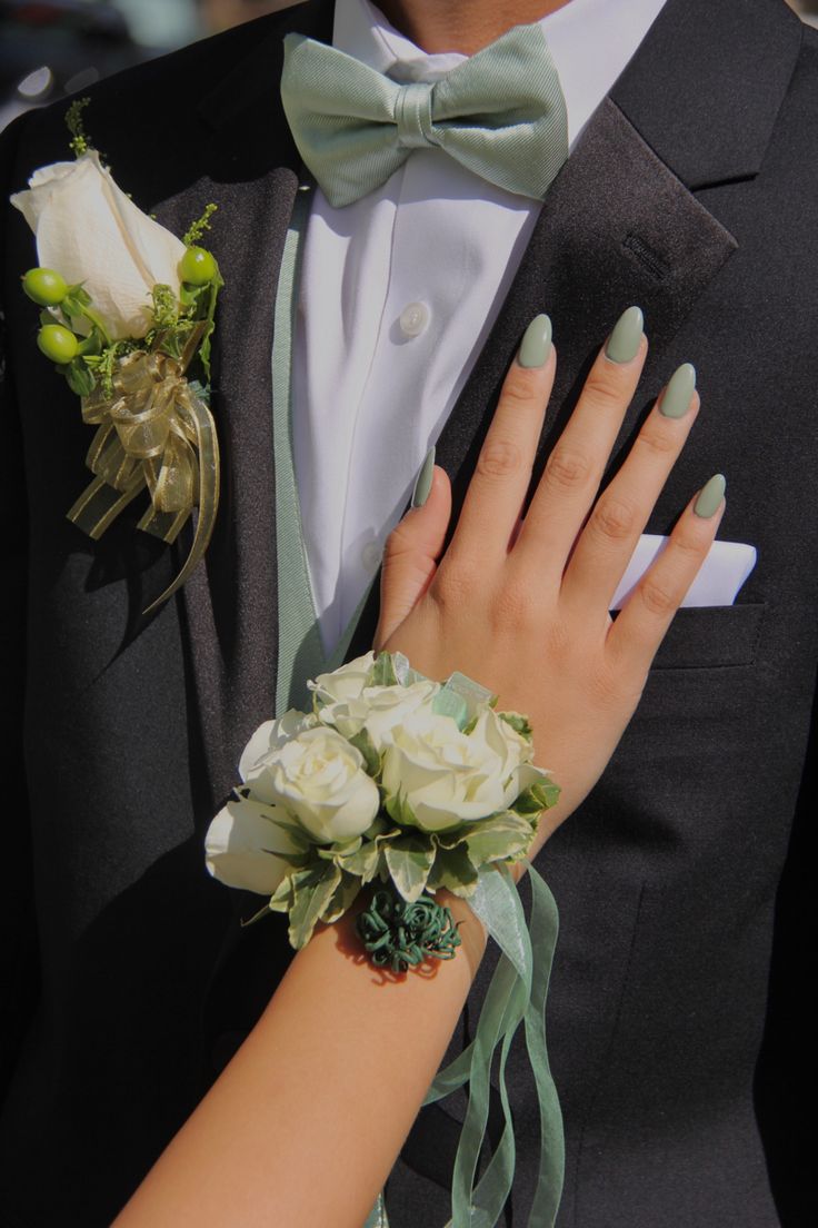 a close up of a person wearing a suit and tie with flowers on his lapel