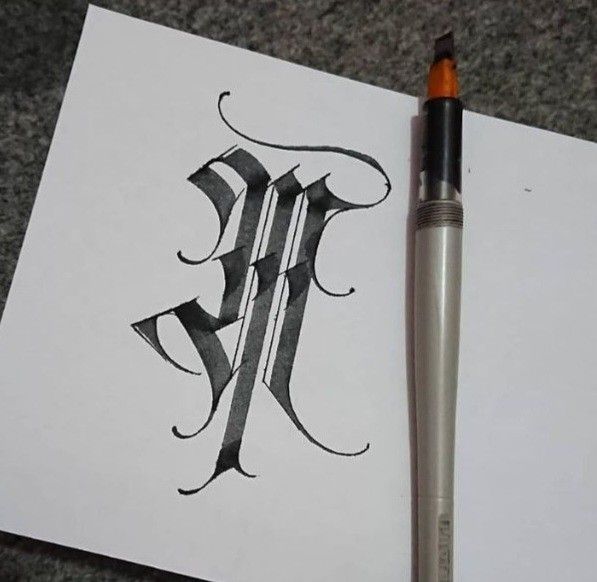 a pen and paper with the letter e on it next to an inking brush