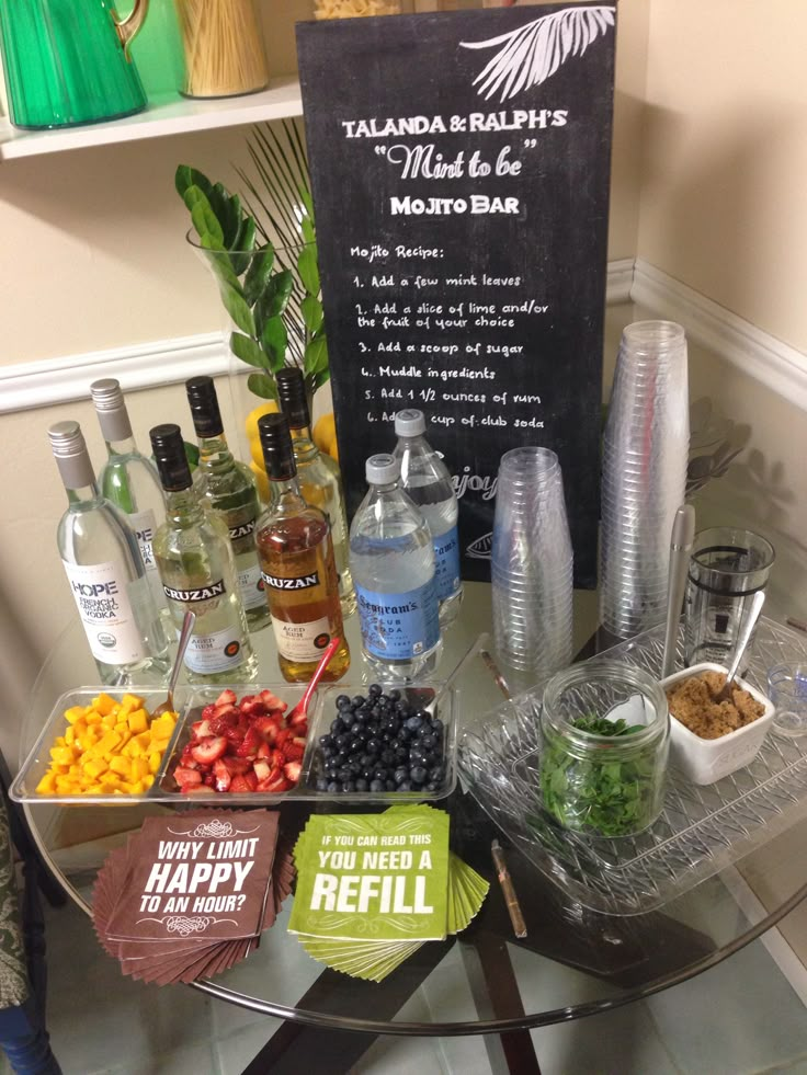 a bar cart filled with liquor bottles and other drinks on top of a glass table