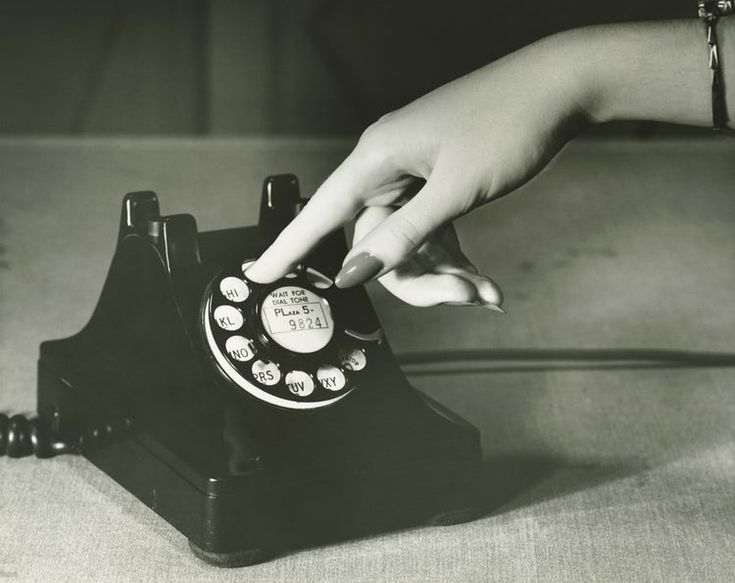 a woman's hand on an old fashioned phone