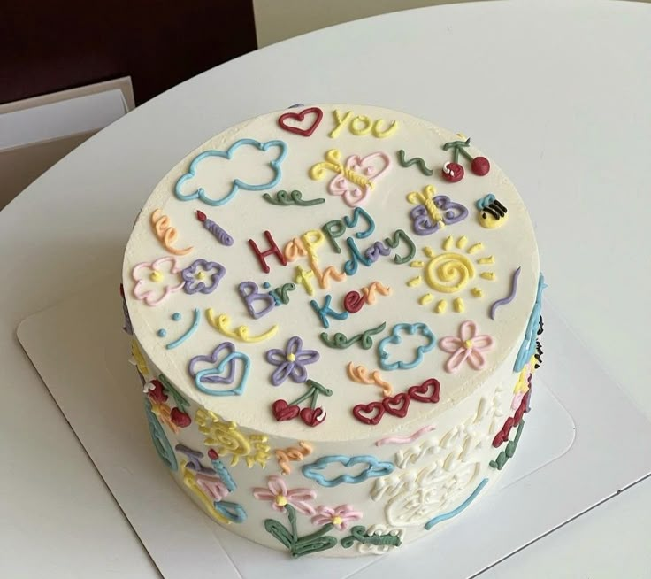 a decorated birthday cake sitting on top of a white table