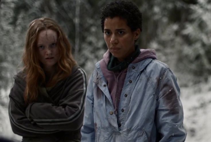 two people standing in the snow with trees behind them