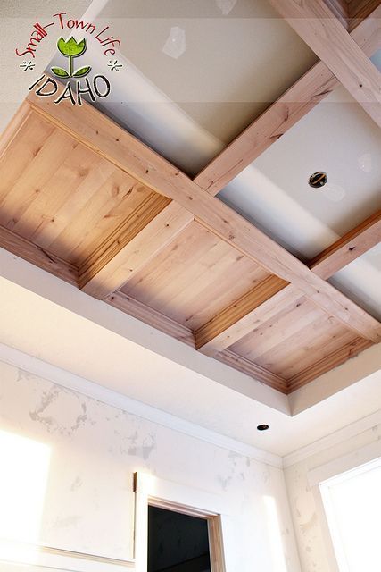 an unfinished ceiling with wooden beams and white walls