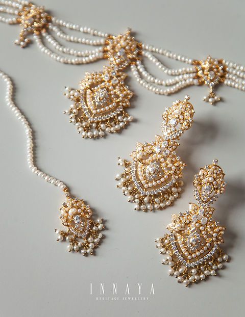 an assortment of gold and white beaded necklaces, earrings and pendants with pearls