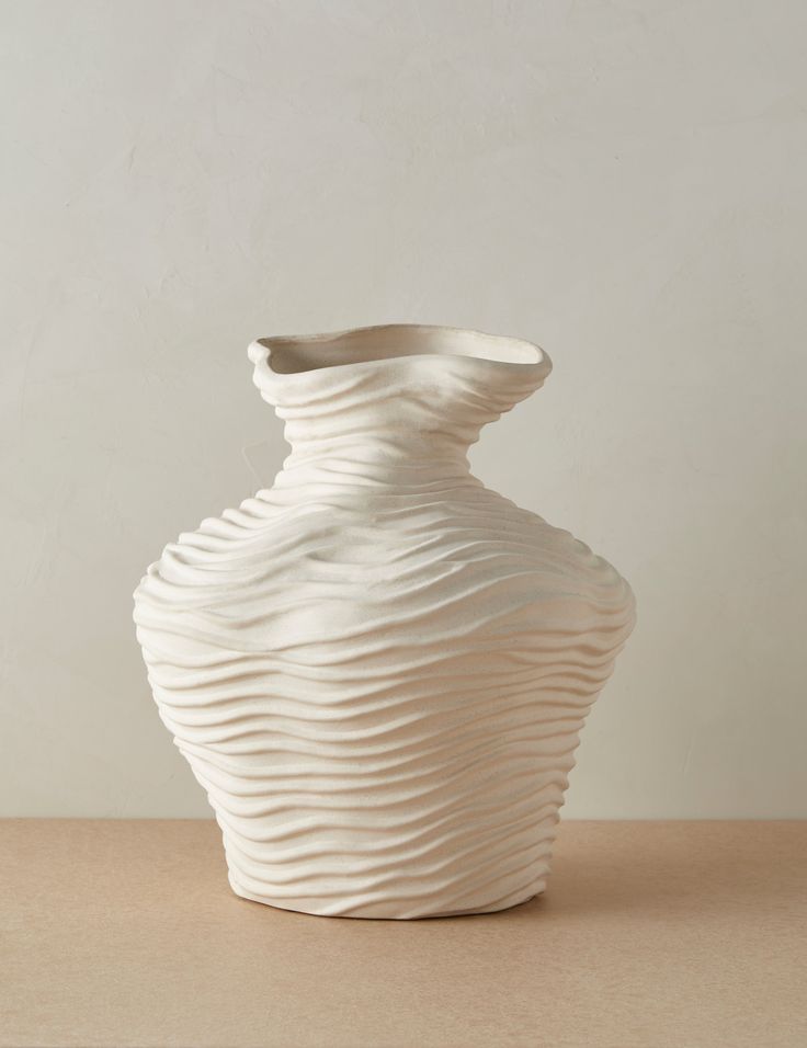 a white vase sitting on top of a table