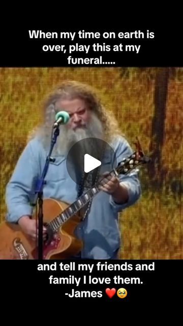 a man with long hair and beard holding a guitar