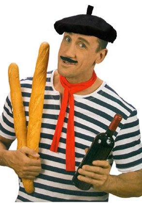 a man in striped shirt holding two large breadsticks next to his face and wearing a black hat