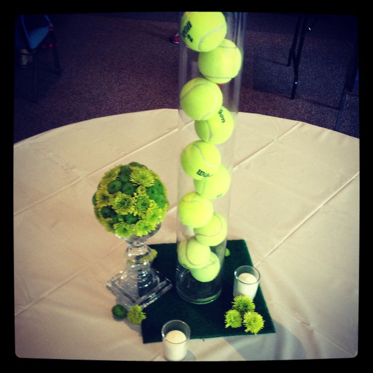 a vase filled with tennis balls sitting on top of a table