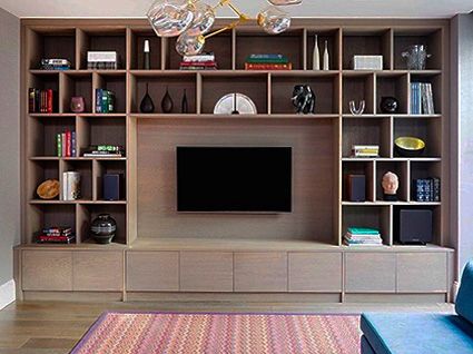 a living room filled with furniture and a flat screen tv mounted on a wooden shelf