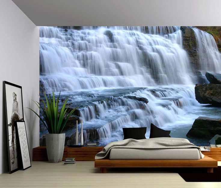 a bedroom with a waterfall wall mural in the corner