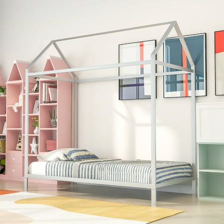 a bedroom with pink and white walls, a metal bed frame and bookshelves