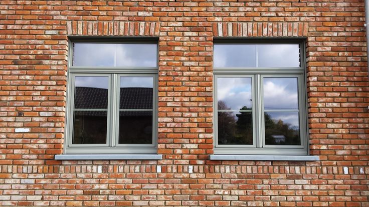 two windows on the side of a brick building