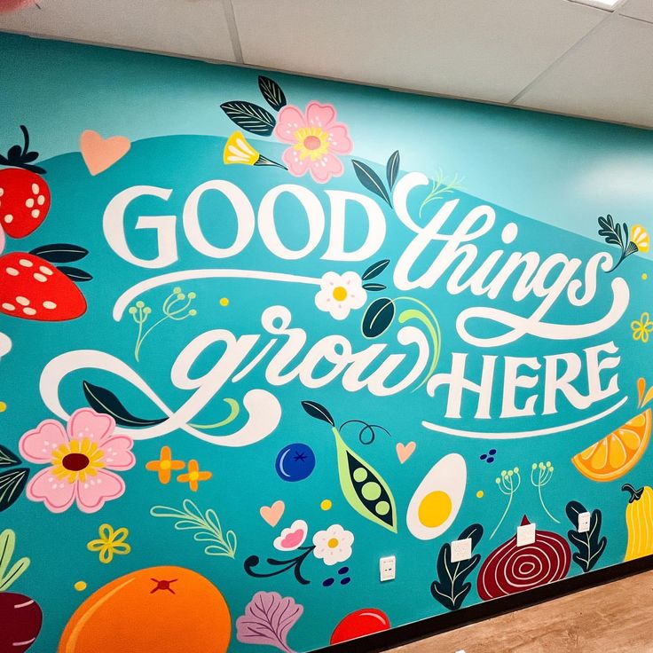 a large mural painted on the side of a building that says good things grow here