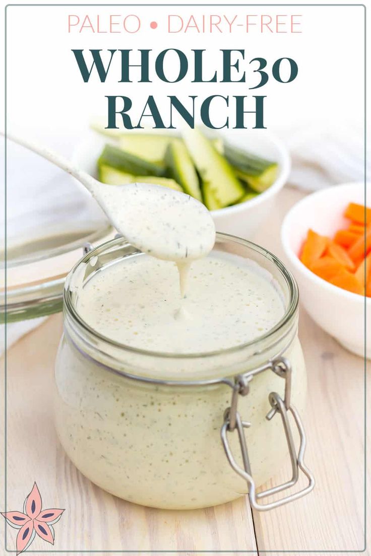 a spoon full of ranch dressing with cucumbers and carrots in the background