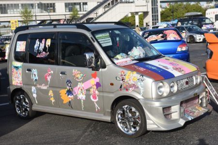 a silver minivan parked in a parking lot next to other cars