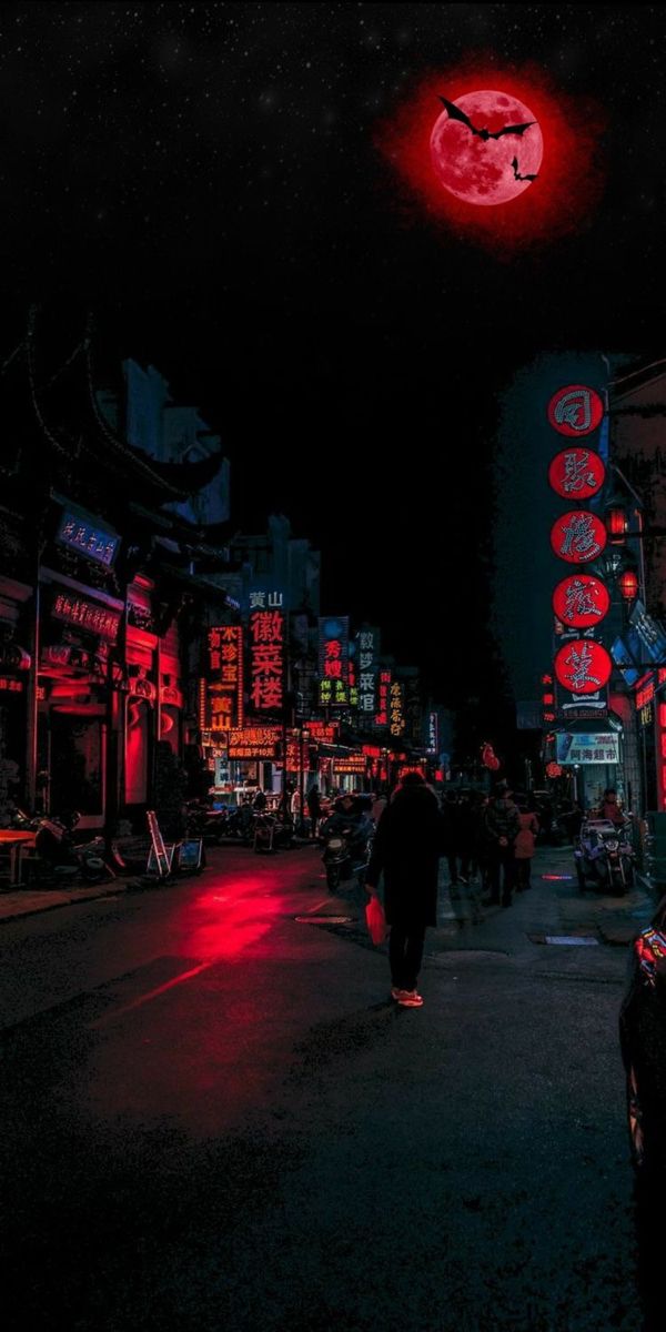 people walking down the street at night with red lights on buildings and signs in the background