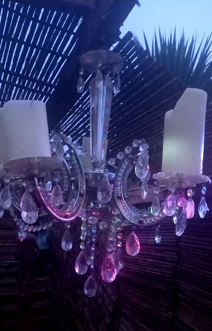 a chandelier with three lights hanging from it's center and two candles on each side