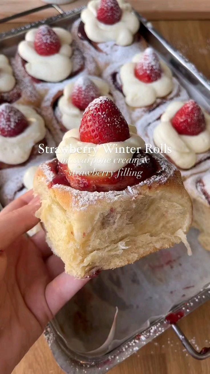 someone is holding up a pastry with strawberries on it