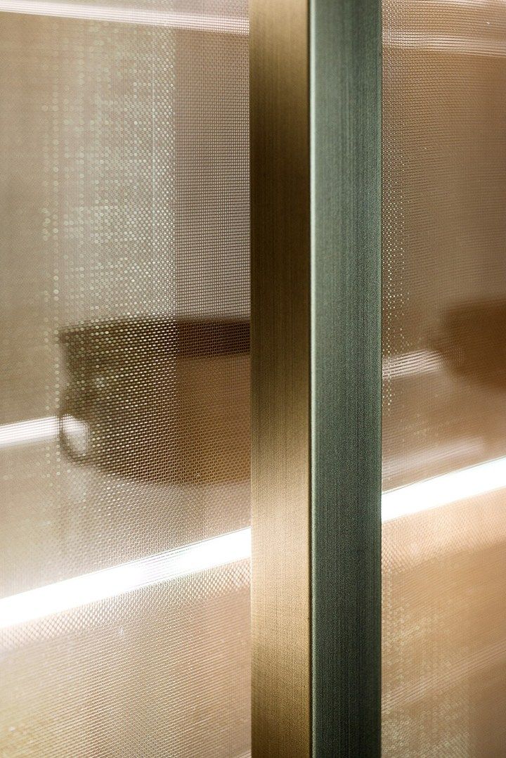 a close up of a glass door in a room with metal trimmings on it