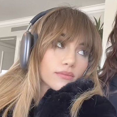 a woman with headphones on looking at the camera