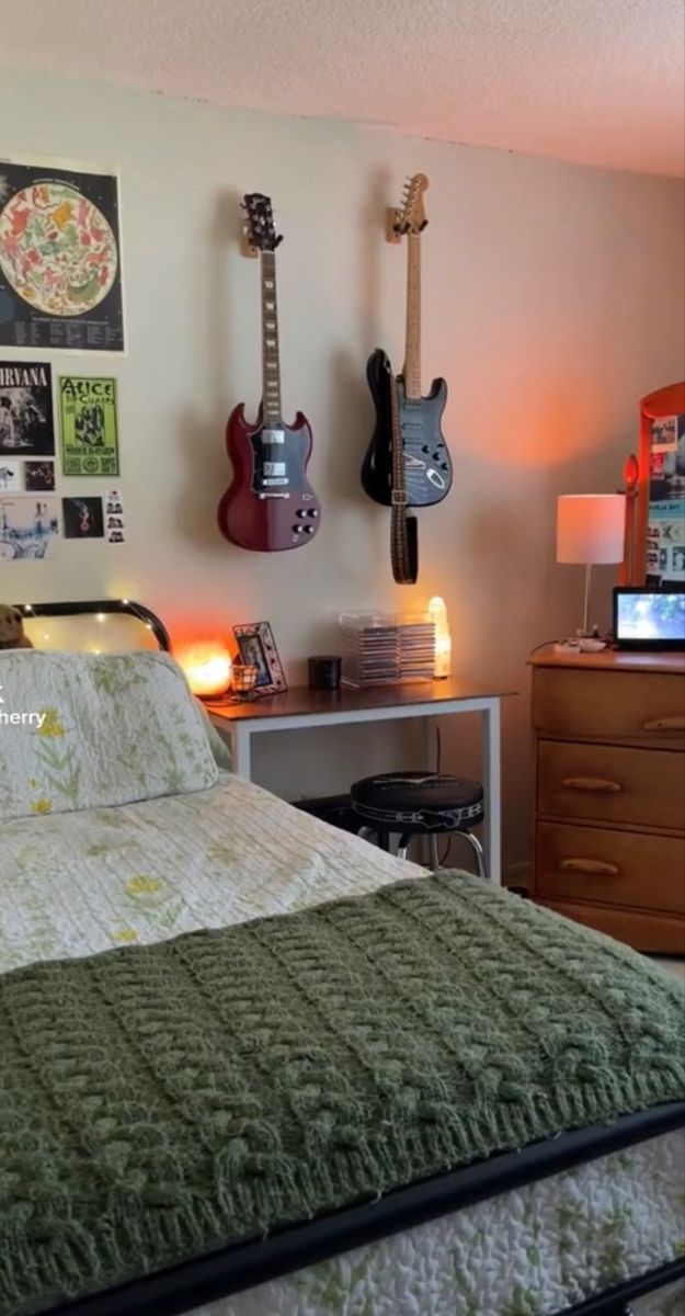 a bed room with a neatly made bed and guitars hanging on the wall above it