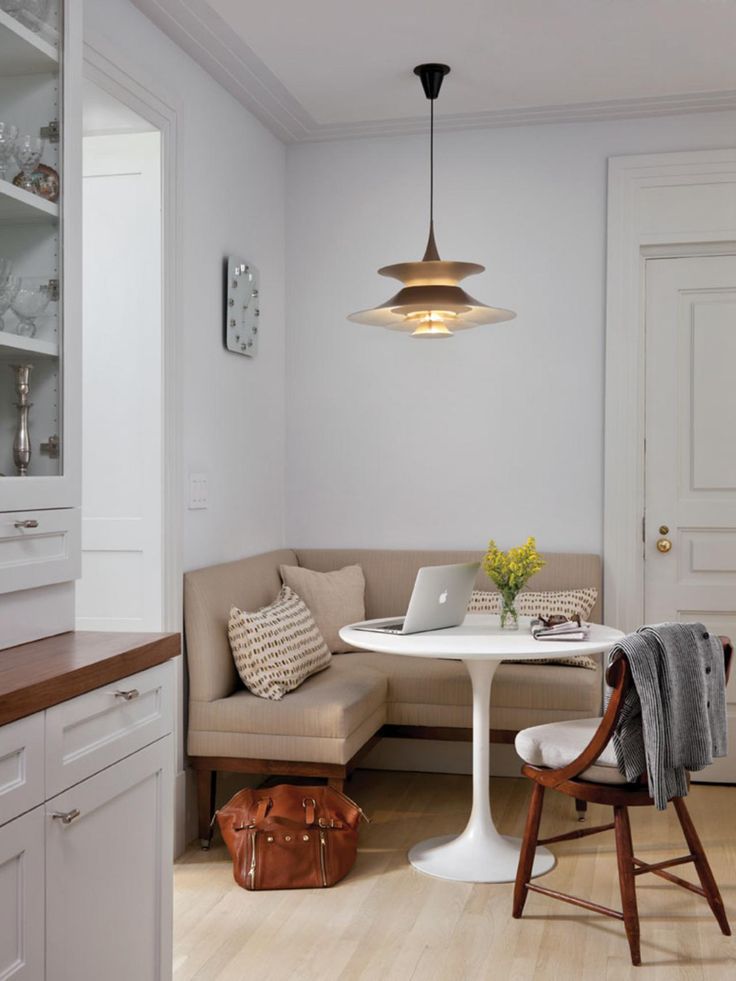 a living room filled with furniture next to a white table and chair under a light fixture