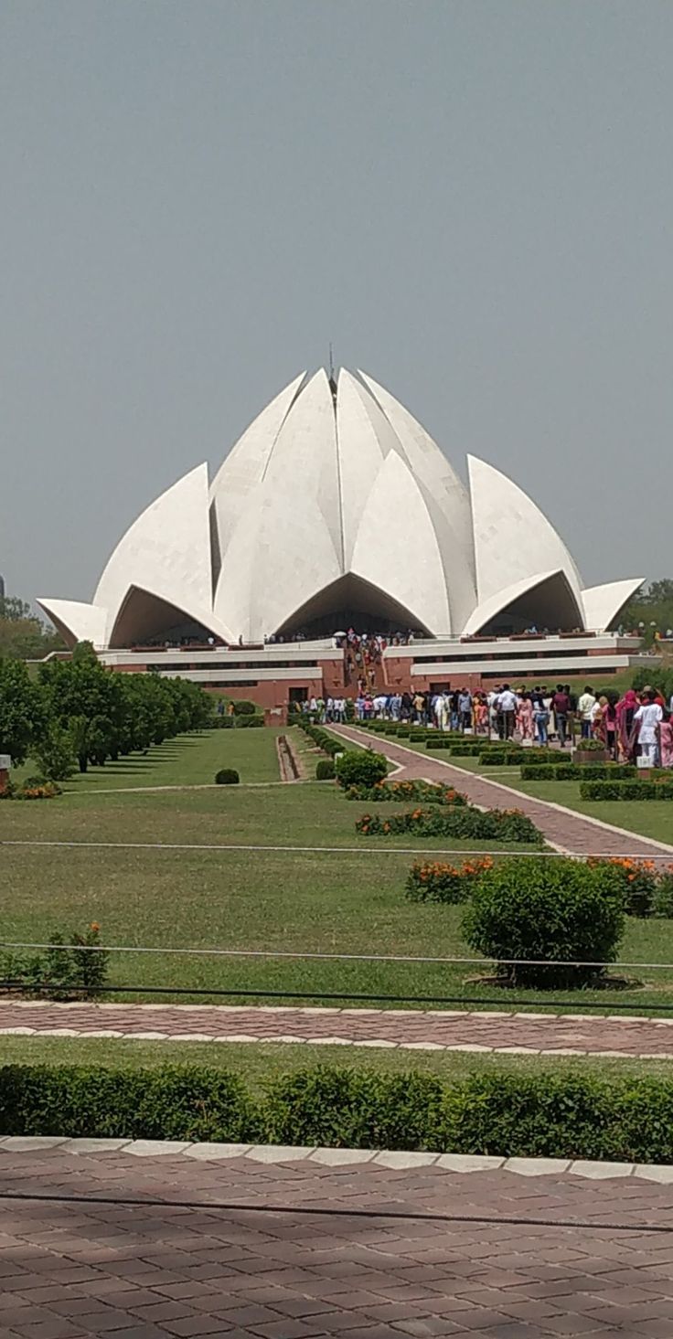 people are standing in front of a large white building with many domes on it's sides