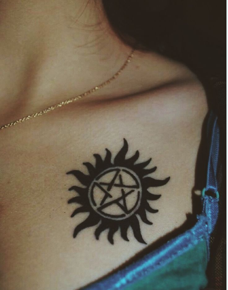 a woman's chest with a pentagramil tattoo on her left side shoulder