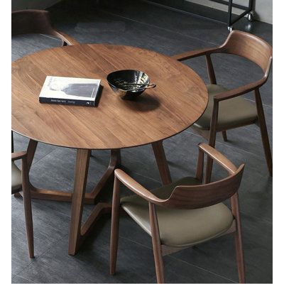 a wooden table with chairs around it and a book on the table next to it