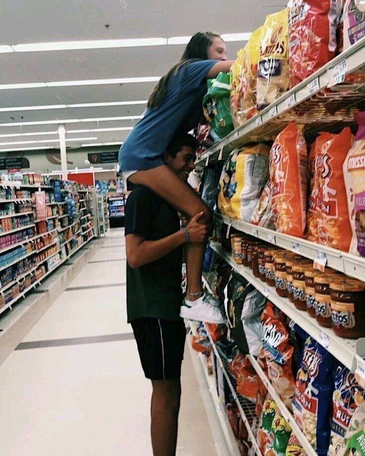 a man and woman are hugging in the aisle of a grocery store