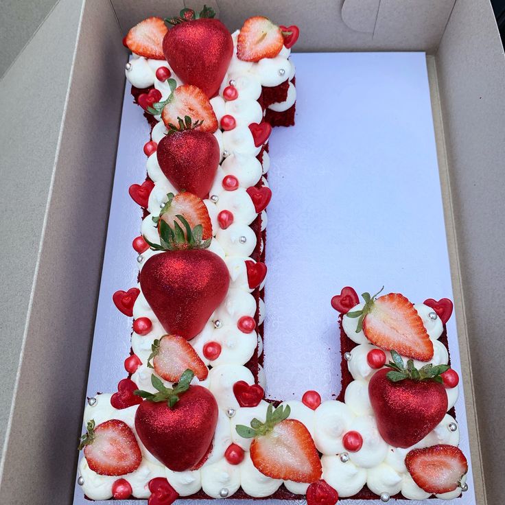 the letter u is made up of strawberries and berries on top of white frosting