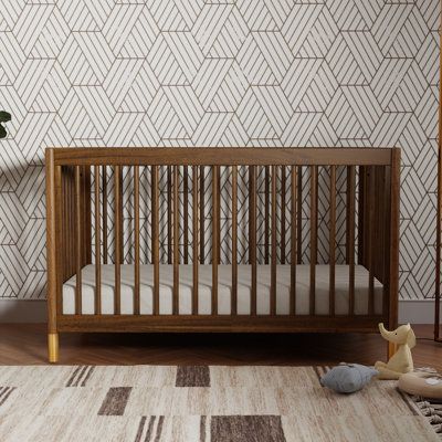 a baby crib sitting on top of a wooden floor next to a white rug