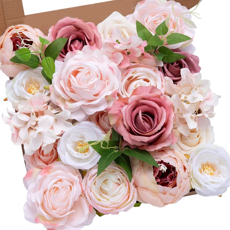 a large bouquet of pink and white flowers in a cardboard box on a white background