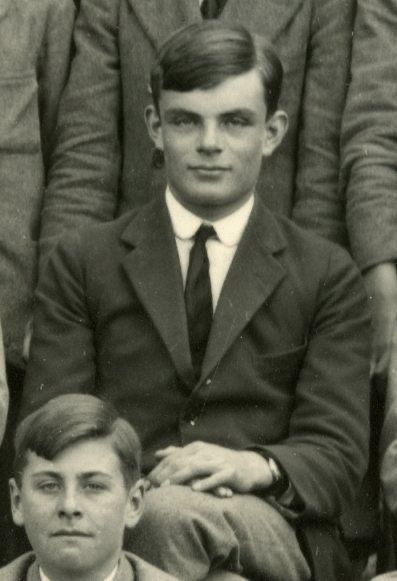 an old black and white photo of a man in suit sitting next to other men