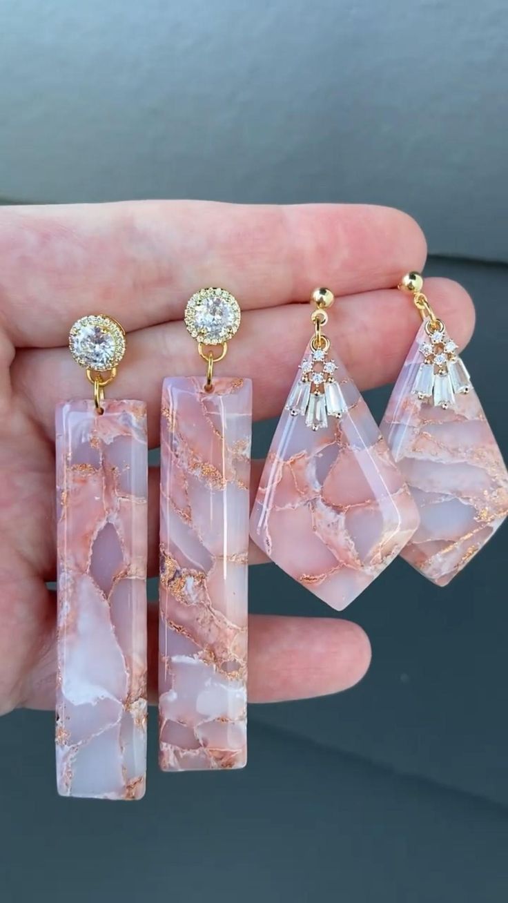 three pieces of pink and gold jewelry in someone's hand