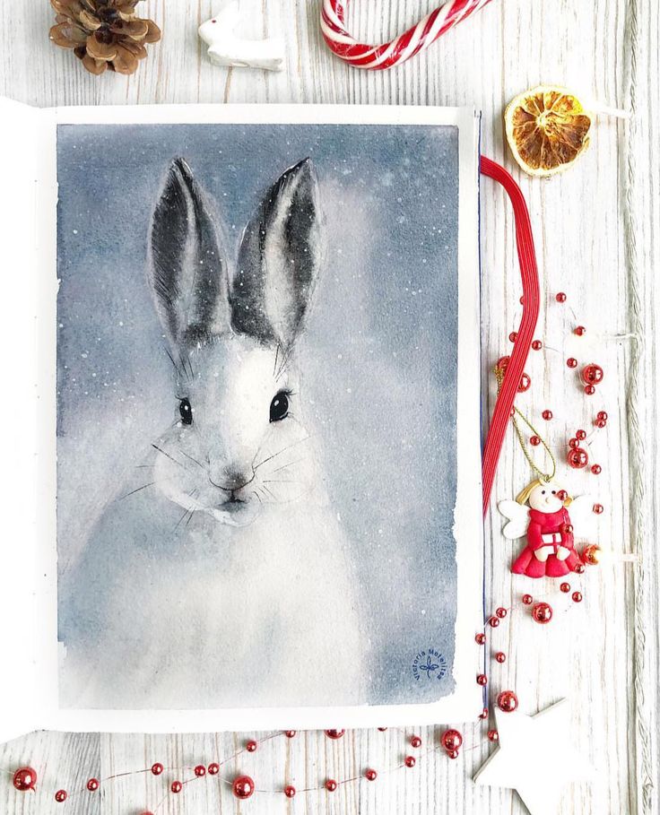 a painting of a white rabbit in the snow surrounded by candy canes and christmas decorations