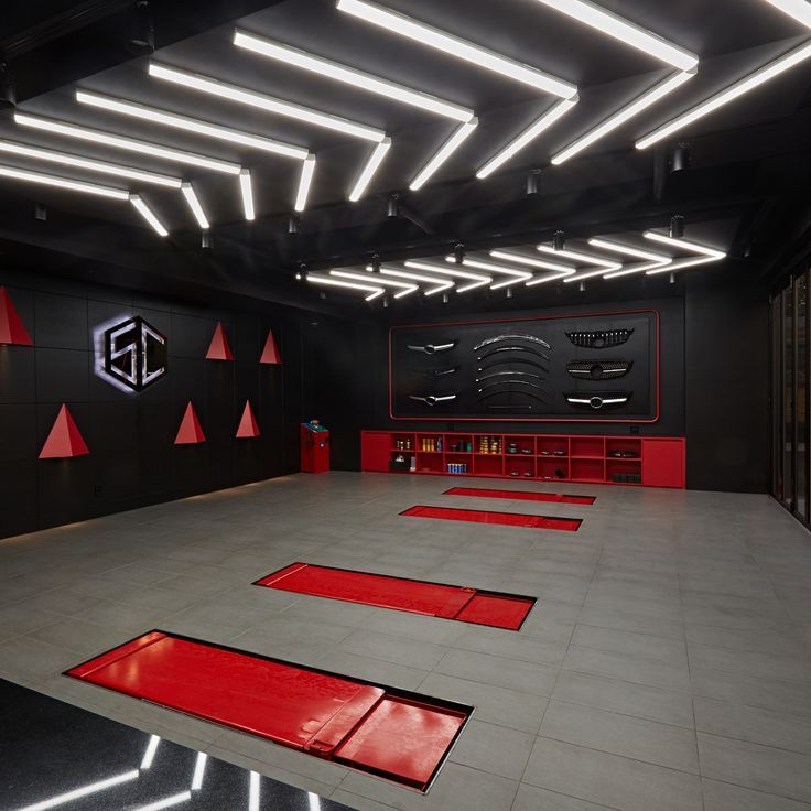 a large room with red and black flooring in the center is lit by recessed lights