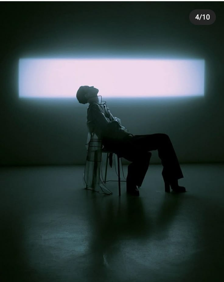 a man sitting on a chair in the dark