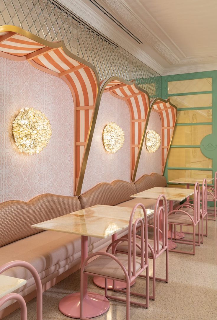 the interior of a restaurant with pink and yellow striped booths, tables and stools