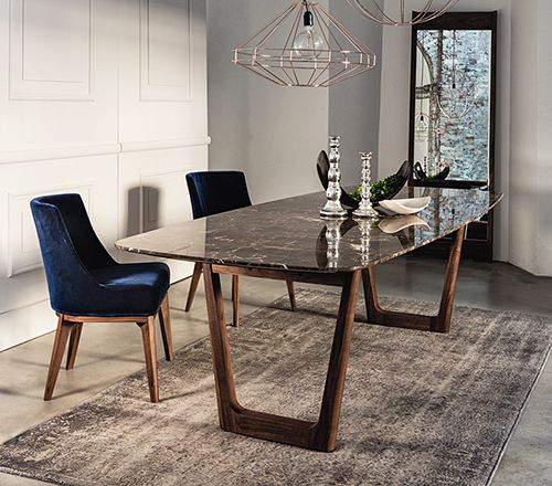 a dining room table with blue chairs and a chandelier hanging from the ceiling