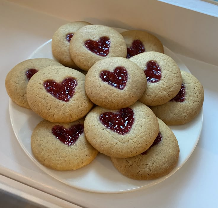 heart shaped cookies are arranged on a white plate